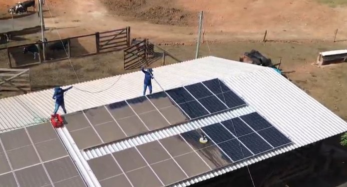 Equipe realizando manutenção em módulos fotovoltaicos no telhado